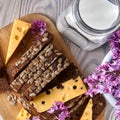 Dark multigrain bread made from rye, wheat, oats and barley with sunflower and flax seeds. Milk, cheese, lilac flowers, rustic Royalty Free Stock Photo