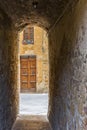 Dark narrow old alley to a street in an Italian city