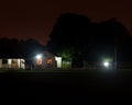 Dark at night cricket grounds with lights on and club house