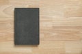 Dark old book cover on wooden table for mockup template Royalty Free Stock Photo