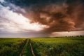 Dark ominous clouds in front of a hurricane over farmland