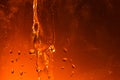 Dark orange background with a flow of liquid