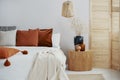 Dark orange and grey pillow on king size bed, copy space on empty wall Royalty Free Stock Photo