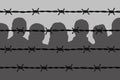 Dark people silhouettes behind barbed wire fencing Royalty Free Stock Photo