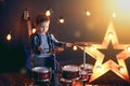 Dark portrait of Beautiful boy playing the drums on a black background with smoke Royalty Free Stock Photo