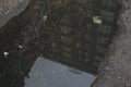 Dark Puddle in Asphalt Road with Reflection of Office Building Royalty Free Stock Photo