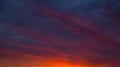Dark purple and blue twilight clouds with a thin strip of bright orange light on the horizon after sunset. Dark Royalty Free Stock Photo