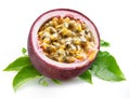 Dark purple passion fruit half with seedy interior laying on green passiflora leaves on white background