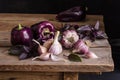 Dark purple peppers with leaves of basil and garlic Royalty Free Stock Photo