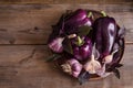 Dark purple peppers with leaves of basil and garlic on old rustic wooden table Royalty Free Stock Photo