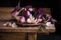 Dark purple peppers with leaves of basil and garlic on old rustic wooden table Royalty Free Stock Photo