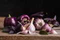 Dark purple peppers with leaves of basil and garlic on old rustic wooden table Royalty Free Stock Photo