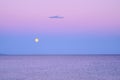 Dark purple sky with yellow moon over sea after sunset Royalty Free Stock Photo