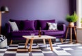 Dark purple sofa with a blanket beside a small table Royalty Free Stock Photo