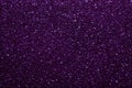 Dark purple sparkling background from small sequins, closeup. Brilliant shiny backdrop from textile.