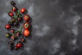Dark Purple Tomatoes rich in anthocyanins, in cluster on the vine and singles atop  dark textured backdrop, top view Royalty Free Stock Photo