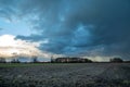 Dark rain cloud over a plowed field Royalty Free Stock Photo