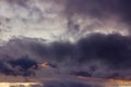 Dark rain clouds during sunset. Dramatic sky during sunset. Dark storm clouds with black and white highlights. Royalty Free Stock Photo