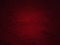 Dark red background with uneven spots and vignetting. Crumpled thick paper texture. Blood red color. Dark frame around the edges