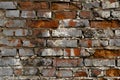 Dark red brick old wall with gray cracked paint, horizontal destroyed brickwork exterior outdoors, close-up. Textured grunge Royalty Free Stock Photo
