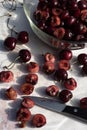 Dark red cherries cut into halves on white cutting board Royalty Free Stock Photo