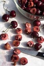 Dark red cherries cut into halves on white cutting board Royalty Free Stock Photo