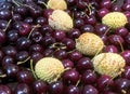 Dark red cherries and Lychees scattered on brown wooden table