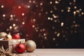 Dark red Christmas tree decorations and Christmas gift. Festive lighting on blurred red bokeh background.