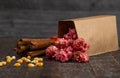 A Bag of Dark Red Cinnamon Popcorn on a Wooden Kitchen Table Royalty Free Stock Photo