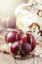 Dark red Easter eggs with gold pattern, apricot flowers,  rustic wooden background, selective focus Royalty Free Stock Photo