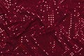 Dark red fabric with sparkling metallic dots design