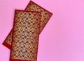 Dark red and golden color Chinese New Year envelopes with pink background. Chinese New Year Concept.