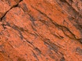 Dark red orange brown rock texture with cracks. Close-up. Rough mountain surface. Royalty Free Stock Photo