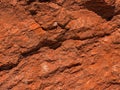 Dark red orange brown rock texture with cracks. Close-up. Rough mountain surface. Royalty Free Stock Photo