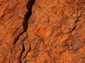 Dark red orange brown rock texture with cracks. Close-up. Rough mountain surface. Royalty Free Stock Photo