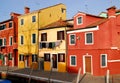 A dark red and other colored house in Burano Venice area Italy Royalty Free Stock Photo