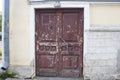 A dark red shabby old front door in an apartment building. Royalty Free Stock Photo