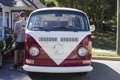 A dark red and white small bus at an outdoor car show