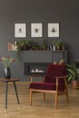 Dark red wooden armchair next to table with flowers in grey loft
