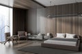 Dark relaxing interior with bed, drawer and armchairs near panoramic window Royalty Free Stock Photo