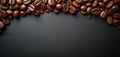 Dark roasted coffee beans arranged on a black textured surface with ample copy space. This image conveys a rich aroma and energy, Royalty Free Stock Photo