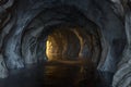 The dark rock tunnel with light illuminated in the end, 3d rendering