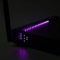 A dark room features a router or modem with illuminated LED lights. The LEDs are Royalty Free Stock Photo