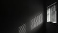 Dark room interior shows light rays and shadows through louvers on wall. Light from lamp and shadows of roller window shutter Royalty Free Stock Photo