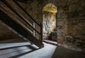 Dark room with stone walls window and wooden staircase Royalty Free Stock Photo