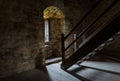 Dark room with stone walls window and wooden staircase Royalty Free Stock Photo