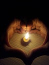 Buring candle, two hands making symbol of Love heart in Dark room Royalty Free Stock Photo