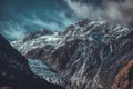 Dark rugged mountains and Franz Josef Glacier