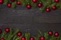 Dark rustic wood table flatlay - Christmas background with red ball ornament decoration and fir branch frame. Top view with free Royalty Free Stock Photo