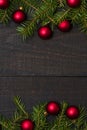 Dark rustic wood table flatlay - Christmas background with red ball ornament decoration and fir branch frame. Top view with free Royalty Free Stock Photo